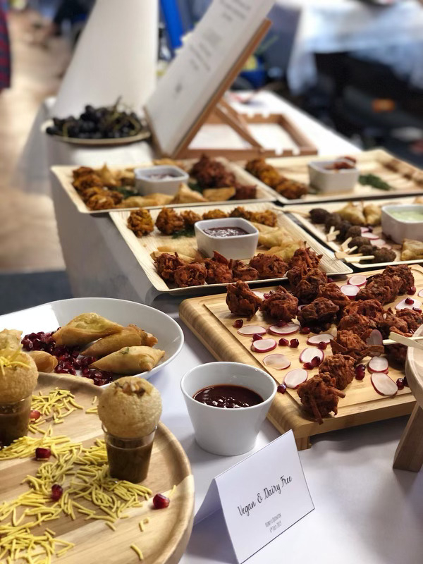 Platter of samosas and vegan appetisers on a wooden board