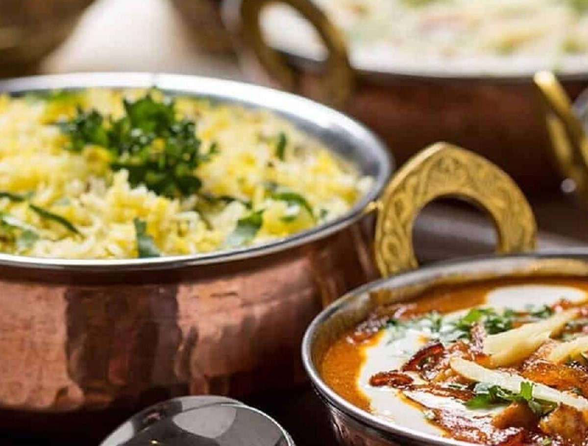 Indian buffet dishes plated in copper serving bowls at a school event